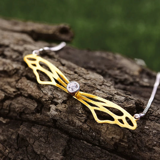 Hollow Butterfly Wings Necklace LFJF0063B gold color on a piece of wood- Tan Tan Gallery