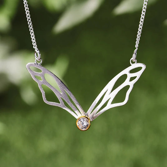 Hollow Butterfly Wings Necklace LFJF0063B silver color with a blurry background- Tan Tan Gallery